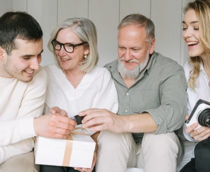 Happy family exchanging gifts together, capturing a joyful moment indoors.