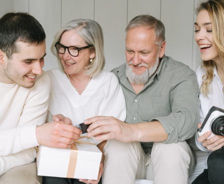 Happy family exchanging gifts together, capturing a joyful moment indoors.